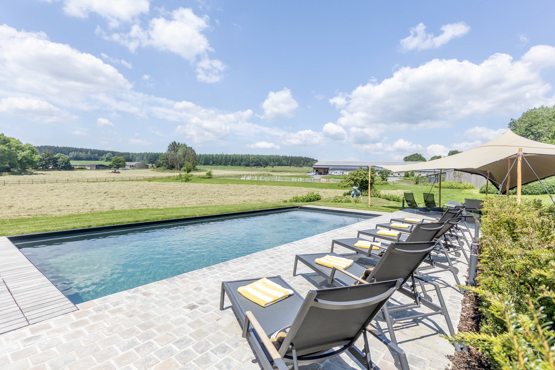 Sun loungers beside the pool overlooking the fields